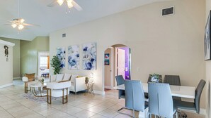 A spacious living area with a dining table, chairs, sofas, and ceiling fans. - Private Pool Villa 5BR  (Davenport)