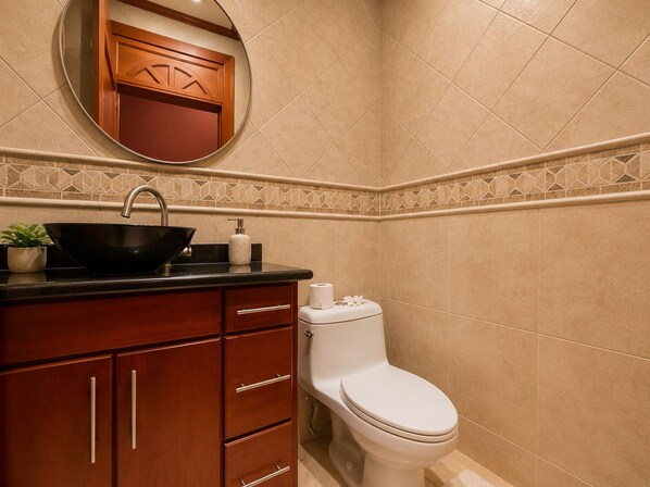 A bathroom with a sink, toilet, and a mirror above the sink.