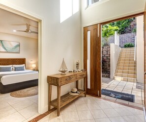 A bedroom with a bed, bedside table, and a ceiling fan.