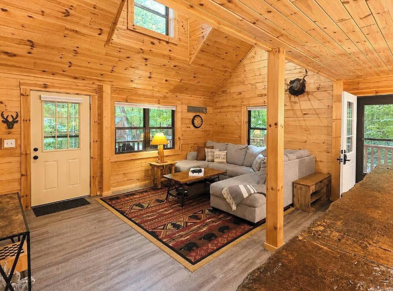 Ein Holzblockhaus-Innenraum mit einer Couch, einem Tisch und einem Teppich.