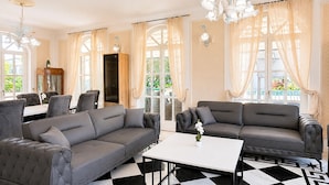 A hotel lobby with a checkered floor, two grey sofas, a white table, and a chandelier. - Awesome home in Porec (Porec)