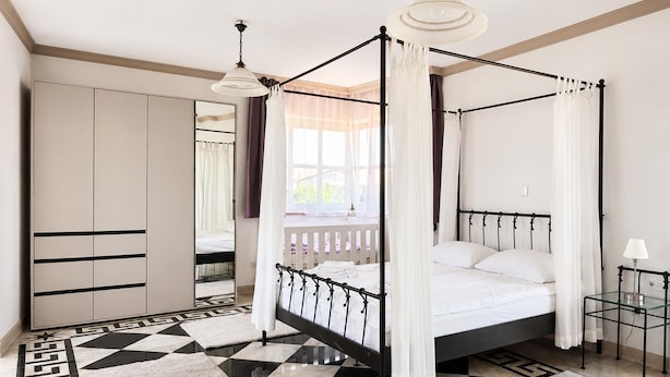 A four-poster bed with a canopy, a mirrored wardrobe, and a checkered floor. - Awesome home in Porec (Porec)
