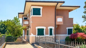 A two-story building with a tiled roof, a gated entrance, and a paved driveway. - Awesome home in Porec (Porec)