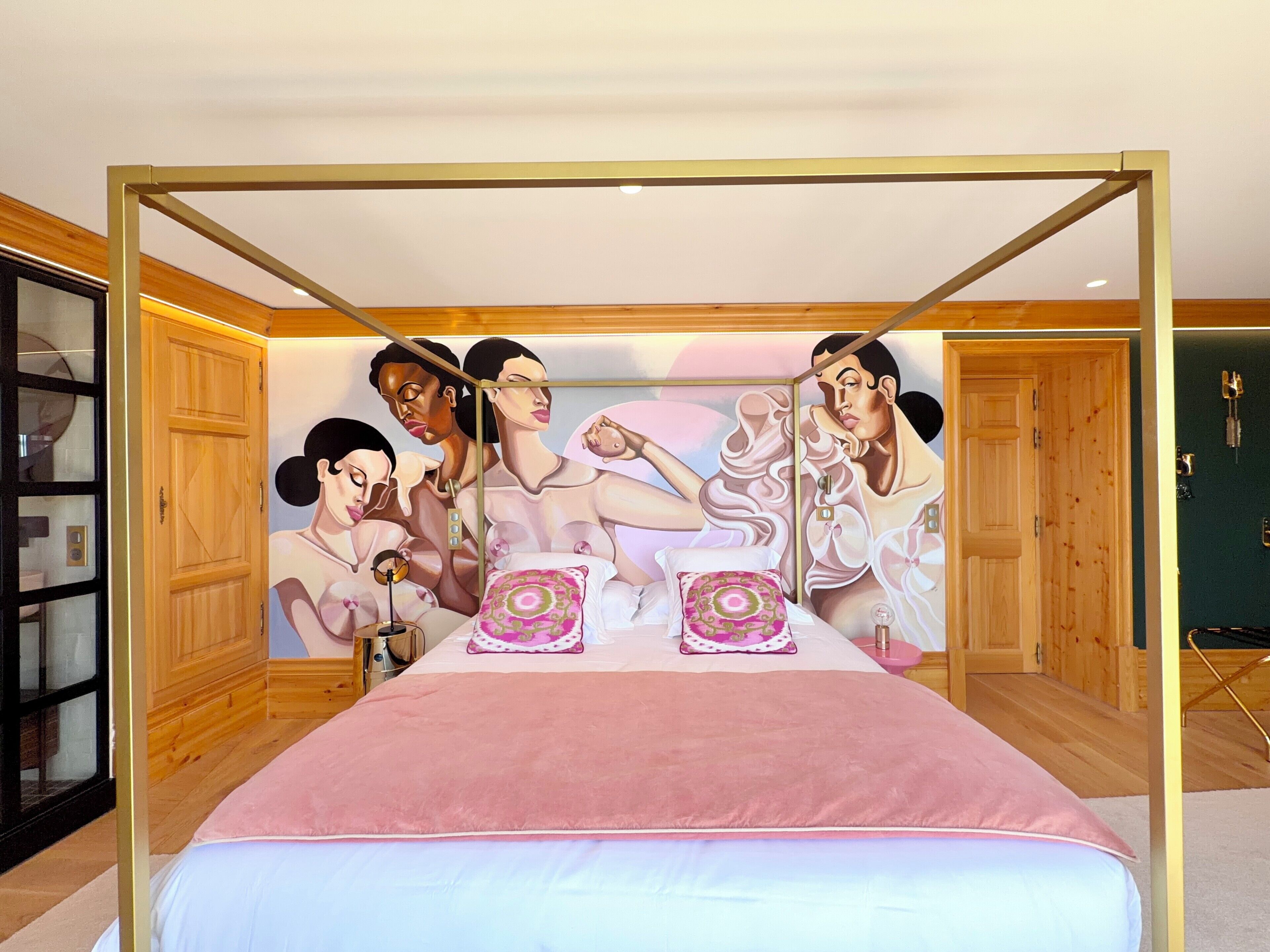 Une chambre à coucher avec un lit à baldaquin, des murs en bois et une grande fresque murale sur le mur du fond.