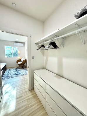 A modern room with a built-in bench, a chair, and a hanging rack. - Boho luxury 2 master suites, huge yard (Alhambra)