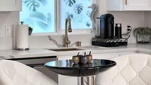 A modern kitchen with a marble countertop, a stainless steel sink, a coffee machine, and a decorative seahorse. - Boho luxury 2 master suites, huge yard (Alhambra)