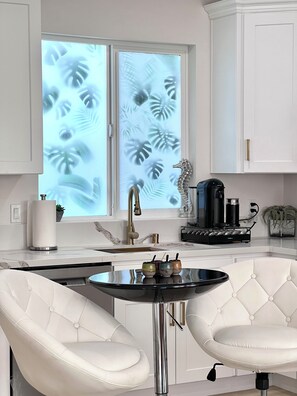 A modern kitchen with a marble countertop, a stainless steel sink, a coffee machine, and a decorative seahorse. - Boho luxury 2 master suites, huge yard (Alhambra)