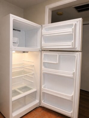 Ein weißer Kühlschrank mit mehreren Ablagen und einem Gefrierfach.