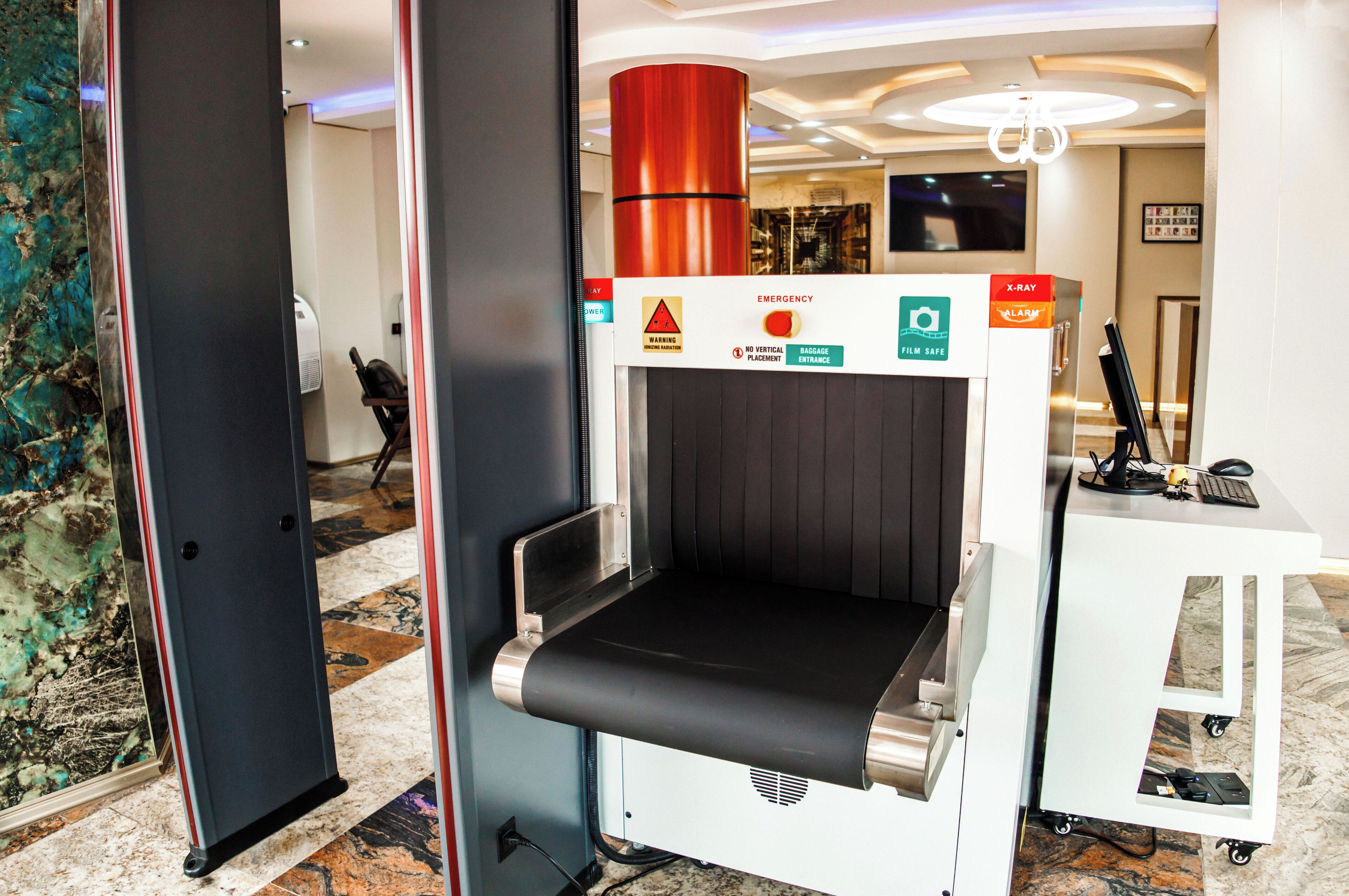 A self-service kiosk with a vertical placement warning, emergency signage, and a no baggage placement sign.
