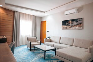 Suite ejecutiva | Área de sala de estar | Televisión LED de 55 pulgadas con canales por cable 
