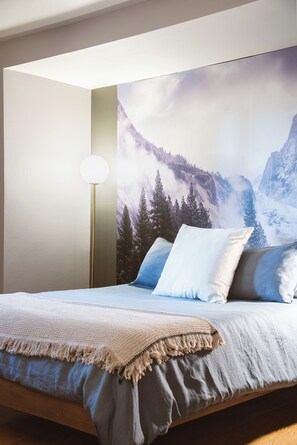 A bedroom with a bed, pillows, a throw blanket, a floor lamp, and a wall mural of a mountain landscape. - Amazing 5 bedroom house in peaceful Lake Arrowhead getaway (Lake Arrowhead)