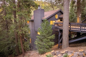 A cabin with a chimney, a deck, and a staircase leading to a second level. - Amazing 5 bedroom house in peaceful Lake Arrowhead getaway (Lake Arrowhead)