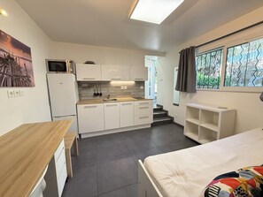 A compact kitchen with white cabinets, a microwave, and a sink. - Studio moderne, climatisé, avec grande terrasse - La Garde (La Garde)