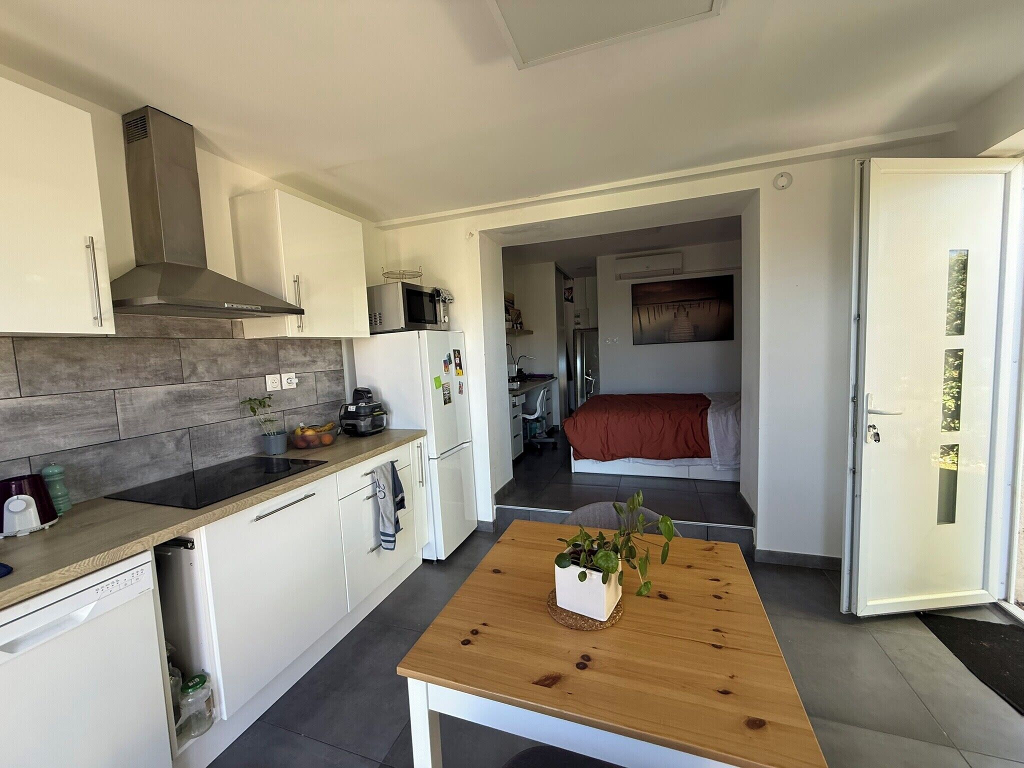 Une cuisine moderne avec une table en bois, un four à micro-ondes et un réfrigérateur.