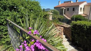 Il s’agit d’une propriété résidentielle dotée d’un escalier en pierre, d’une clôture en métal et d’une variété de plantes, notamment des plantes à fleurs.