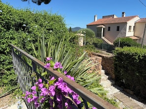 A residential property with a stone staircase, a metal fence, and a variety of greenery including flowering plants. - Studio cosy dans villa, climatisé, terrasse - La Garde (La Garde)