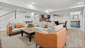 A spacious living room with a sofa set, a coffee table, and a staircase. - First Cast Foley - Fully Renovated Barn Home (Foley)