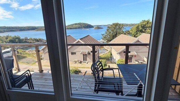 Uma varanda com vista para um lago e edifícios.