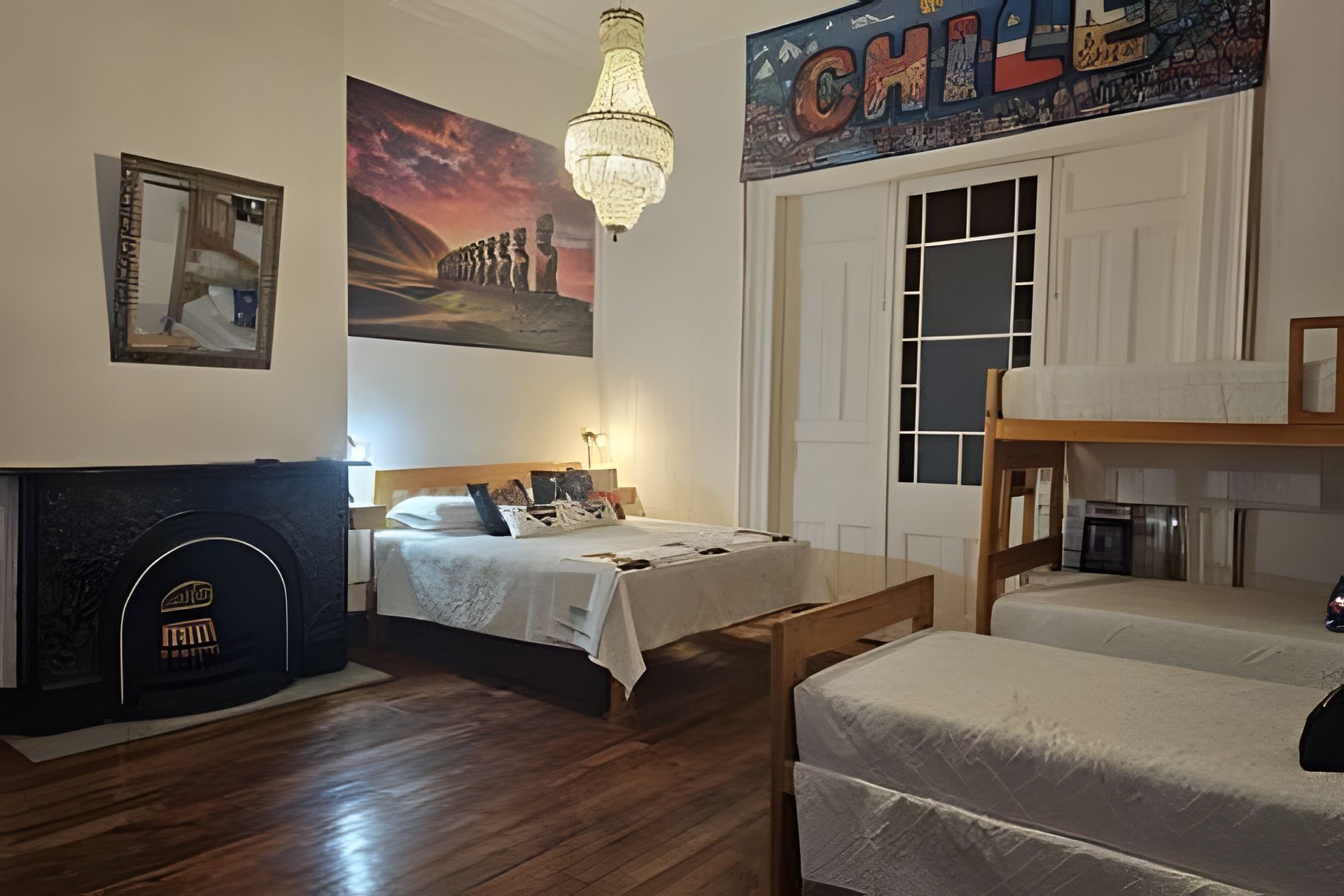 Un dormitorio con una cama, una cama litera de madera, una chimenea y un mural en la pared.