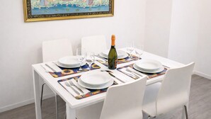 A dining table set with white plates, wine glasses, and a bottle of champagne. - Cozy Urban Retreat | 2BR | Family Getaway in Rome (Rome)