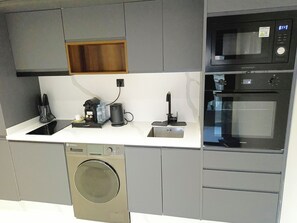 A modern kitchen with a built-in washer, a coffee machine, and a microwave. - Executive Studio/The Princesses/Free Parking. (Dar-el-Beida)