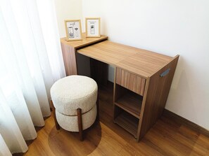 A compact wooden desk with a built-in shelf, a round stool, and two framed pictures on the wall. - Executive Studio/The Princesses/Free Parking. (Dar-el-Beida)