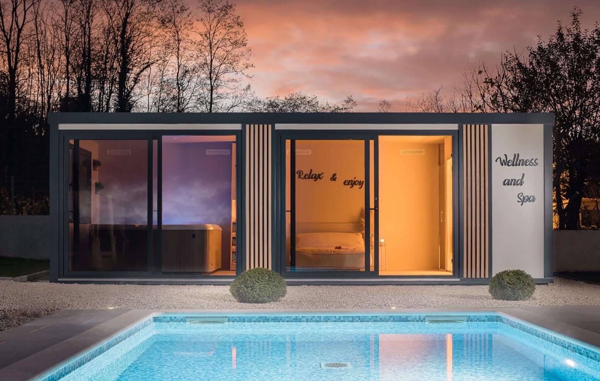 A modern building with a pool, large glass doors, and a sign that reads 'Relax & enjoy Wellness and Spa.'