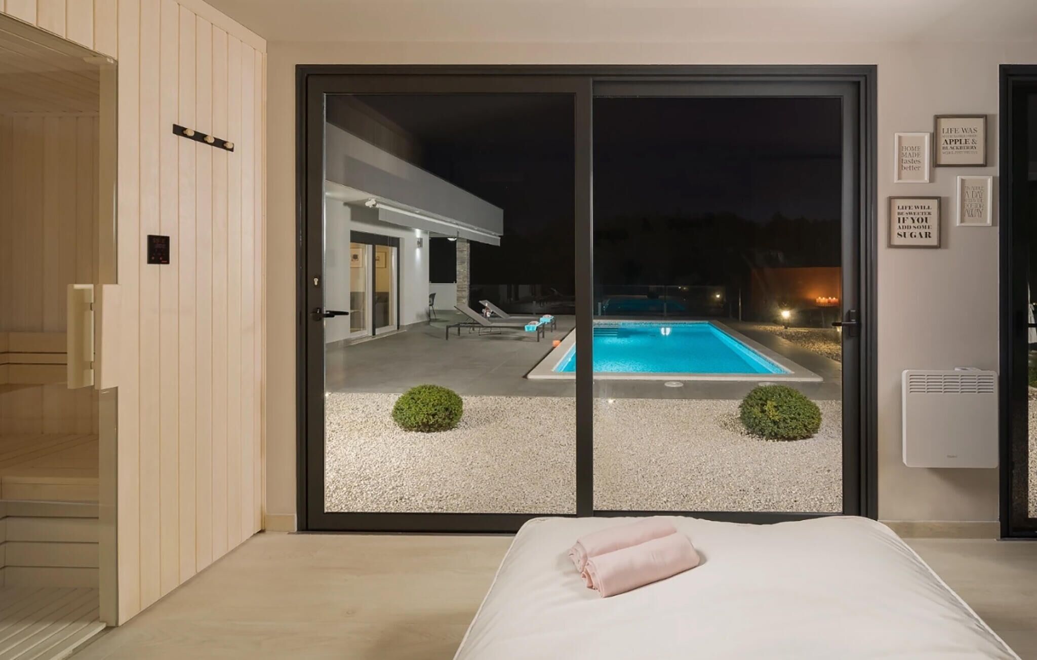 Une chambre avec vue sur une piscine, de nuit.