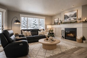 Ein Wohnzimmer mit Kamin, einer Couch, einem Couchtisch und einer Lampe.