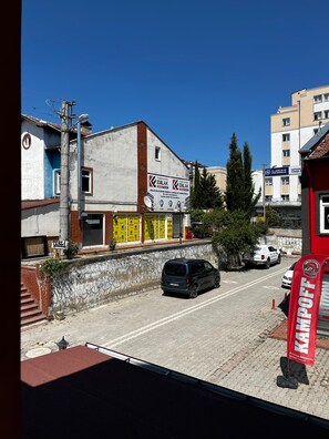 Vista de la calle con un edificio que muestra un letrero de club deportivo, un automóvil estacionado y un banderín rojo.