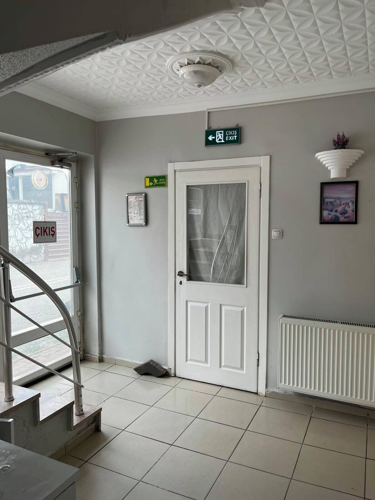 A clean, modern interior with a white door, a staircase, and a radiator.