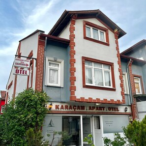 Un edificio con un cartel que indica 'Karacam Apart Hotel' y un número de contacto.