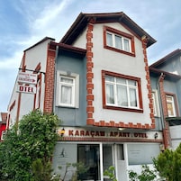 Um edifício com uma placa indicando 'Karacam Apart Hotel' e um número de contato.