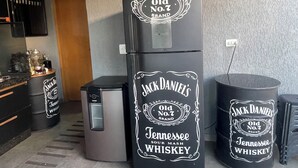 Ett kök med ett kylskåp och två behållare märkta med texten ”Jack Daniels Tennessee Sour Mash Whiskey”.