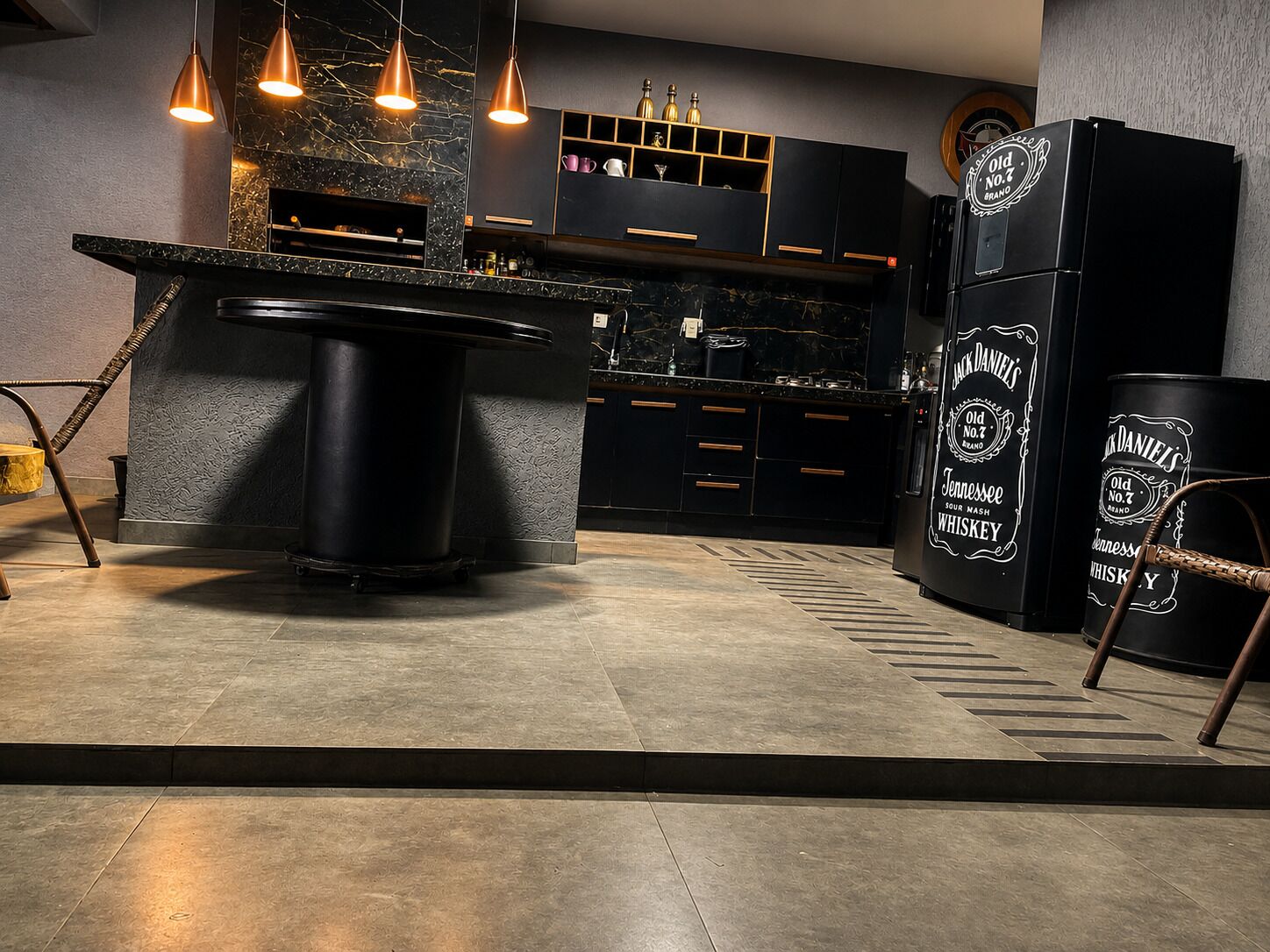 Une cuisine moderne dotée d’un îlot central, de meubles de couleur noire et d’un réfrigérateur en forme de tonneau à whisky.