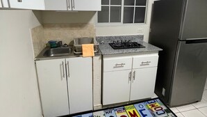 A small kitchen with white cabinets, a stainless steel refrigerator, a window, and a welcome mat. - Private room in Panama City, near the airport (Panama)