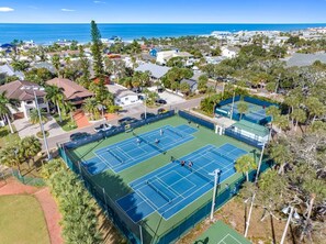 A tennis court surrounded by residential buildings and palm trees. - July Deals - Pet Friendly and Hot tub! Suite B (Indian Rocks Beach)