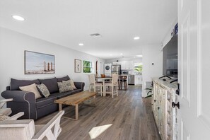 A modern living room with a sofa, coffee table, and dining area. - July Deals - Pet Friendly and Hot tub! Suite B (Indian Rocks Beach)