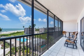 Ein Balkon mit Blick auf Strand, Pool und Gebäude.