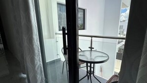 A modern balcony with a glass door, a round table, and a chair. - Spacious 4-bedroom townhome in lovely Punta Cana with AC and free WiFi (Punta Cana)