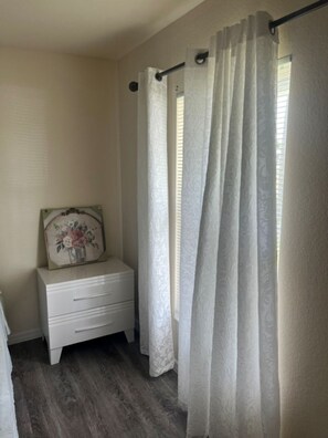 A bathroom with a white nightstand, a framed picture, and a shower curtain. - Relaxing Port LaBelle Retreat / Spacious Home Near Nature & Golf (Port LaBelle)
