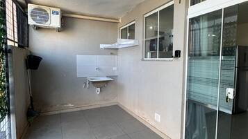A clean, tiled room with a ceiling fan, a window, and a sliding glass door.