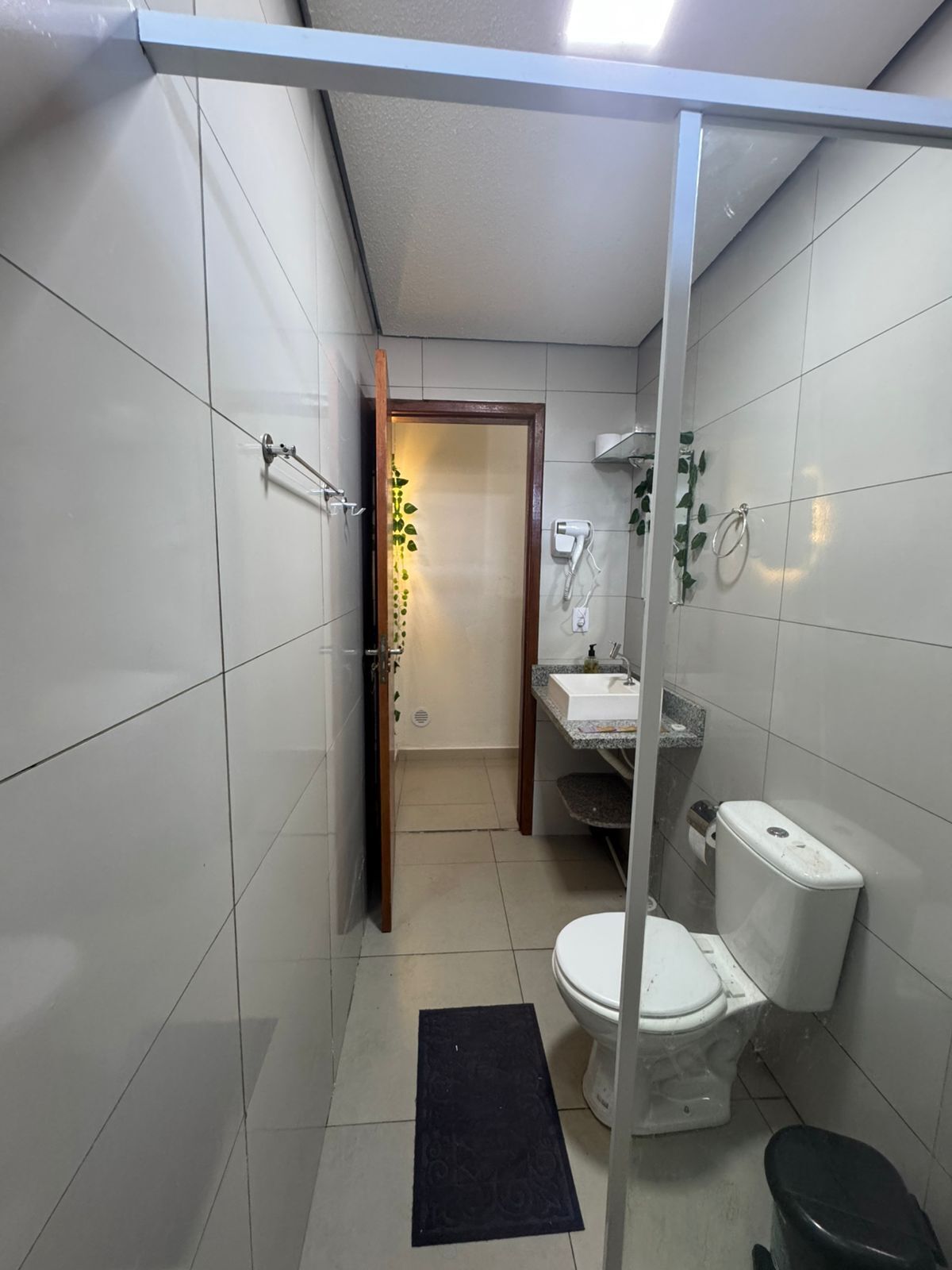 A compact bathroom with a toilet, sink, and shower area.