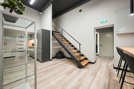 A modern interior with a staircase, a kitchen area, and a seating space.