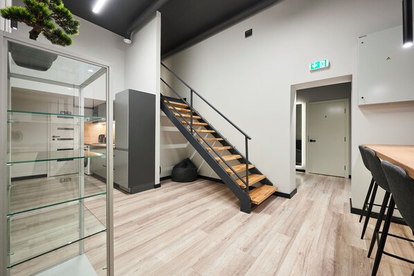 Un intérieur moderne comprenant un escalier, un coin cuisine et un espace salon.