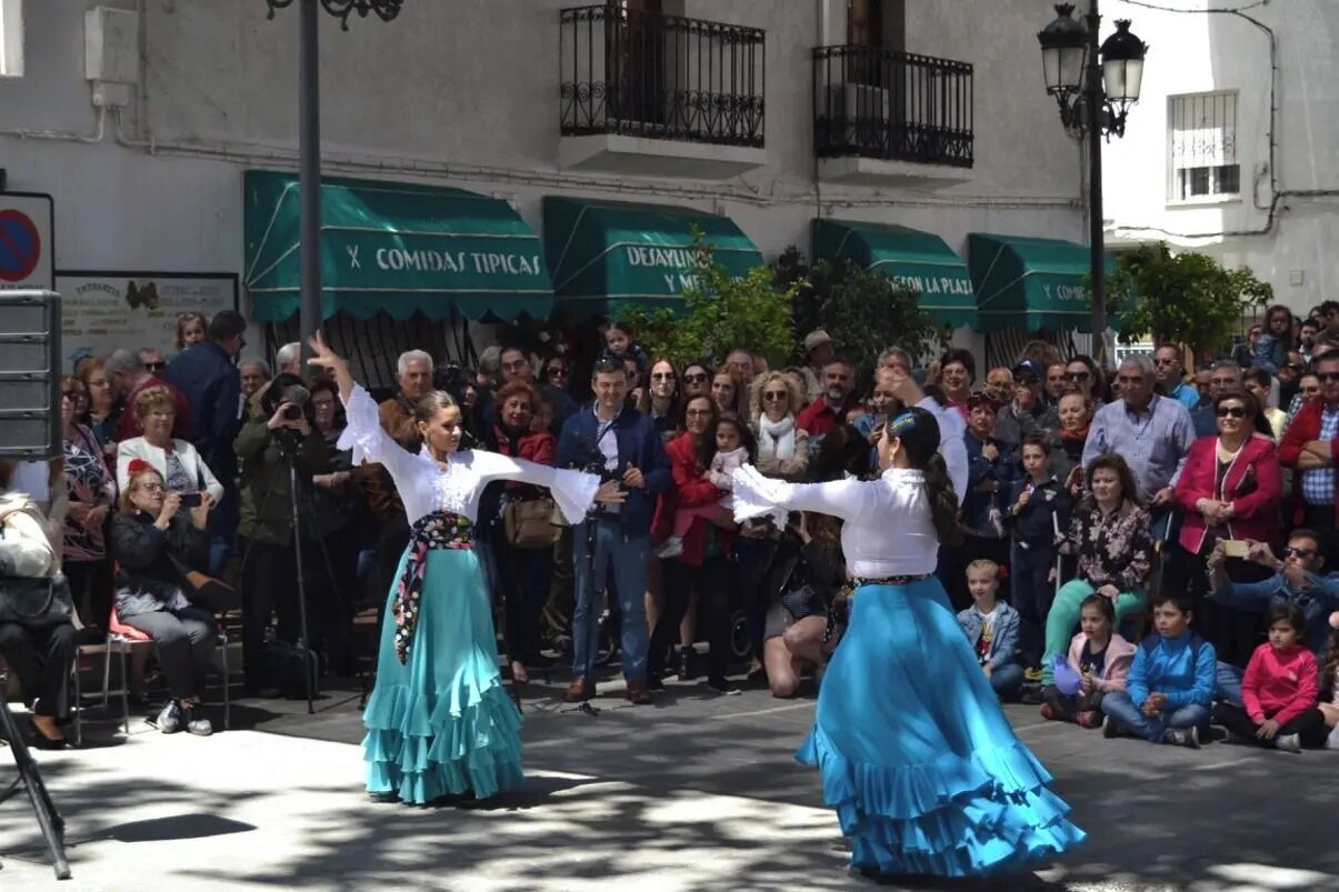 A street performance with dancers in traditional attire.