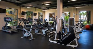 Et fitnesscenter med løbebånd, crosstrainere og styrkeudstyr.