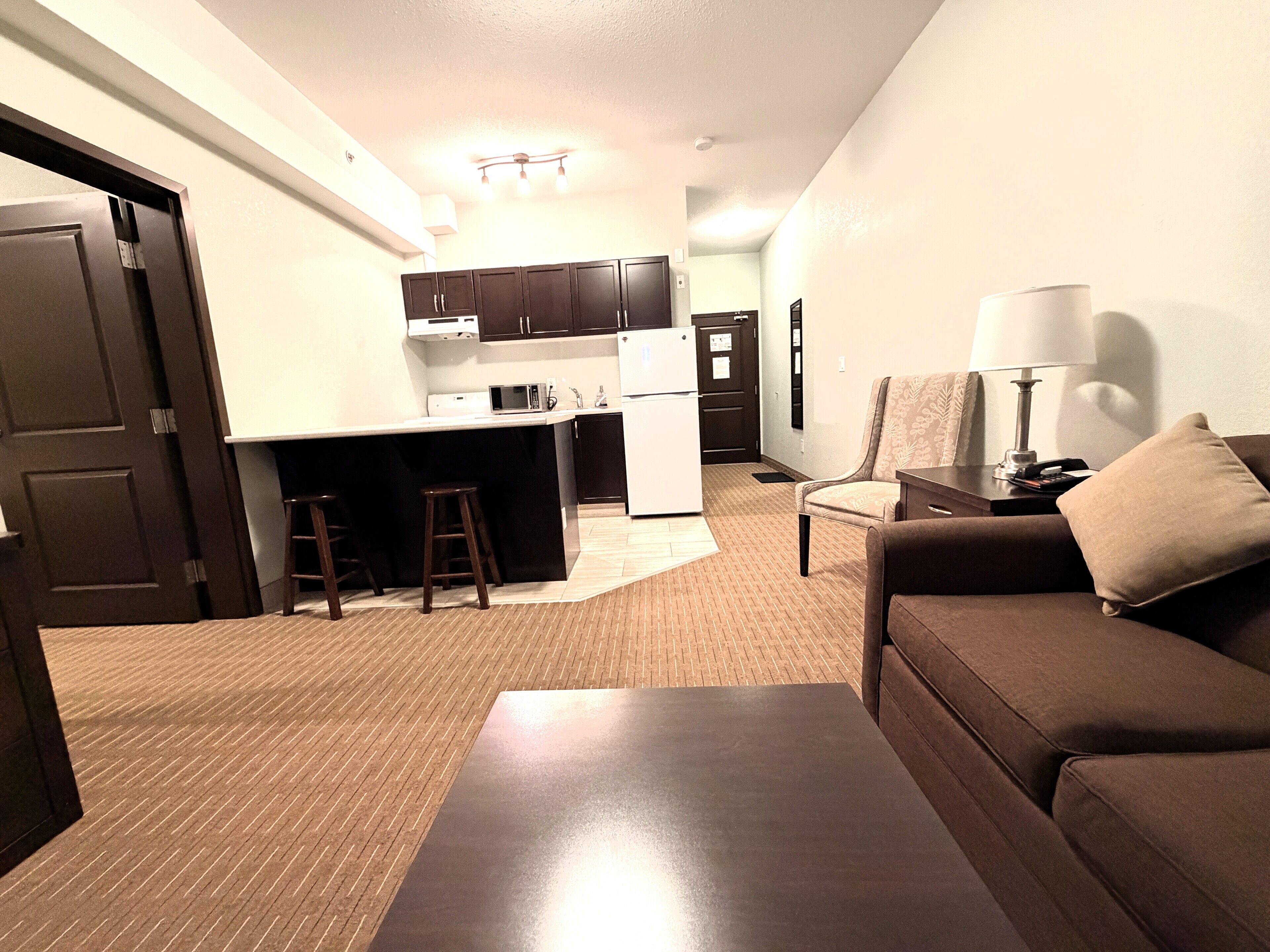 A compact living space with a kitchenette, a sofa, a coffee table, and a small dining area.