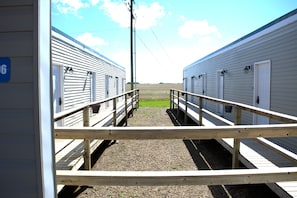 A view of a building with a wooden walkway leading to a door marked with the number 6.