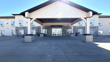 A building with a covered entrance, stone facade, and multiple windows.